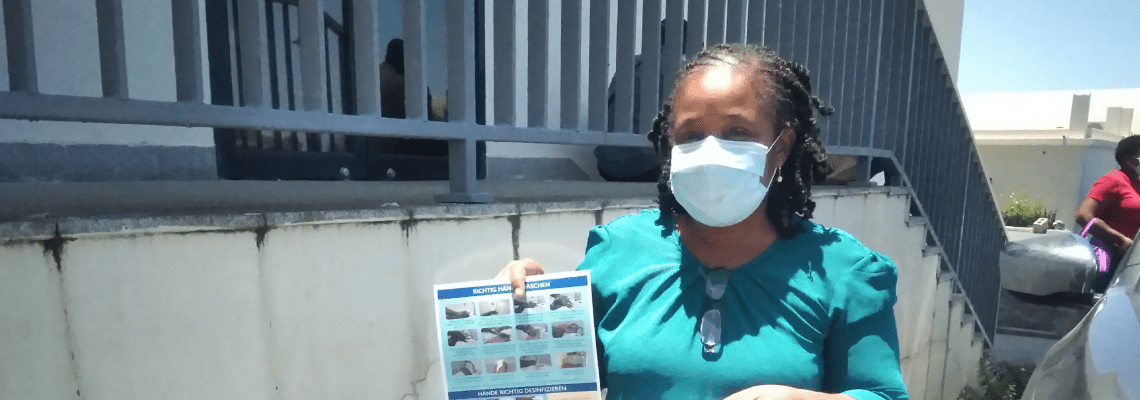 Mujer con mascarilla posa con bolsa de la OIM