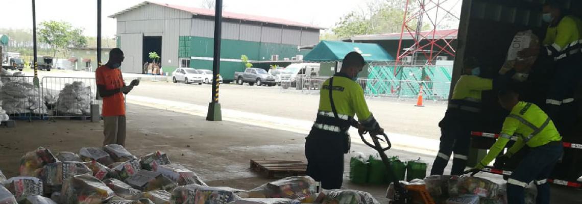 Personas clasifican donaciones de alimentos para personas migrantes en la zona del Darién