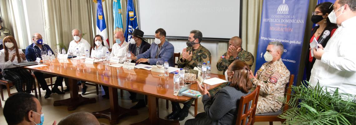 Personas funcionarias con mascarilla dan declaraciones en el evento de clausura