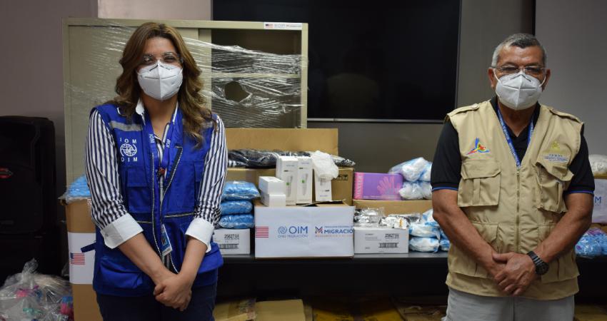 Likza Salazar, oficial de la OIM, entrega donación a Wilfredo Calderón, subdirector del IMN.