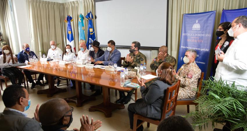 Personas funcionarias con mascarilla dan declaraciones en el evento de clausura