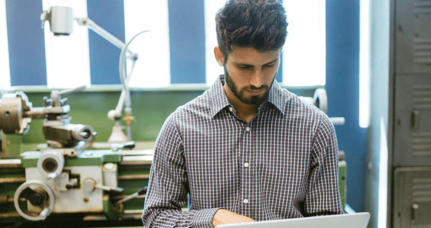 Illustrative image of man working in an industrial looking space with machinery.