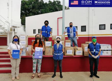 Equipo de la OIM realiza entrega de donación en Tapachula, personas llevan mascarillas de protección y se encuentran distanciadas. 